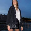 Le petit sac à main fer à cheval noir en cuir est en aspect croco. Avec des petites dimensions, ce sac est chic et élégant. Ce petit sac à main fer à cheval se ferme aisément grâce à un rabat et un fermoir aimanté aux finitions en métal pour plus de sécurité. L'intérieur possède un compartiment muni d'une poche latérale zippée et d'une poche simple. Pour encore plus de praticité, il dispose d'une poche zippée à l'extérieur. Le modèle est équipé d'une bandoulière réglable en chaîne métallisée. Fabriqué en Italie | Dovelya