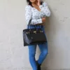 Le sac à main cadenas noir est en matière synthétique. C'est un accessoire tendance et pratique qui convient à toutes les occasions. Vous pouvez le porter à la main ou au coude grâce à ses solides double poignée. Vous pouvez également le porter à l'épaule ou en croisé grâce à sa bandoulière réglable et amovible. Il est équipé d'une fermeture à glissière, il dispose de deux compartiments séparés par une fermeture zippée, ainsi qu'une poche latérale zippée et deux poches ouvertes. Le petit cadenas doré situé au milieu du sac ajoute une touche de fantaisie à l'extérieur | Dovelya