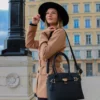 Le sac à main cadenas noir est en matière synthétique. C'est un accessoire tendance et pratique qui convient à toutes les occasions. Vous pouvez le porter à la main ou au coude grâce à ses solides double poignée. Vous pouvez également le porter à l'épaule ou en croisé grâce à sa bandoulière réglable et amovible. Il est équipé d'une fermeture à glissière, il dispose de deux compartiments séparés par une fermeture zippée, ainsi qu'une poche latérale zippée et deux poches ouvertes. Le petit cadenas doré situé au milieu du sac ajoute une touche de fantaisie à l'extérieur | Dovelya