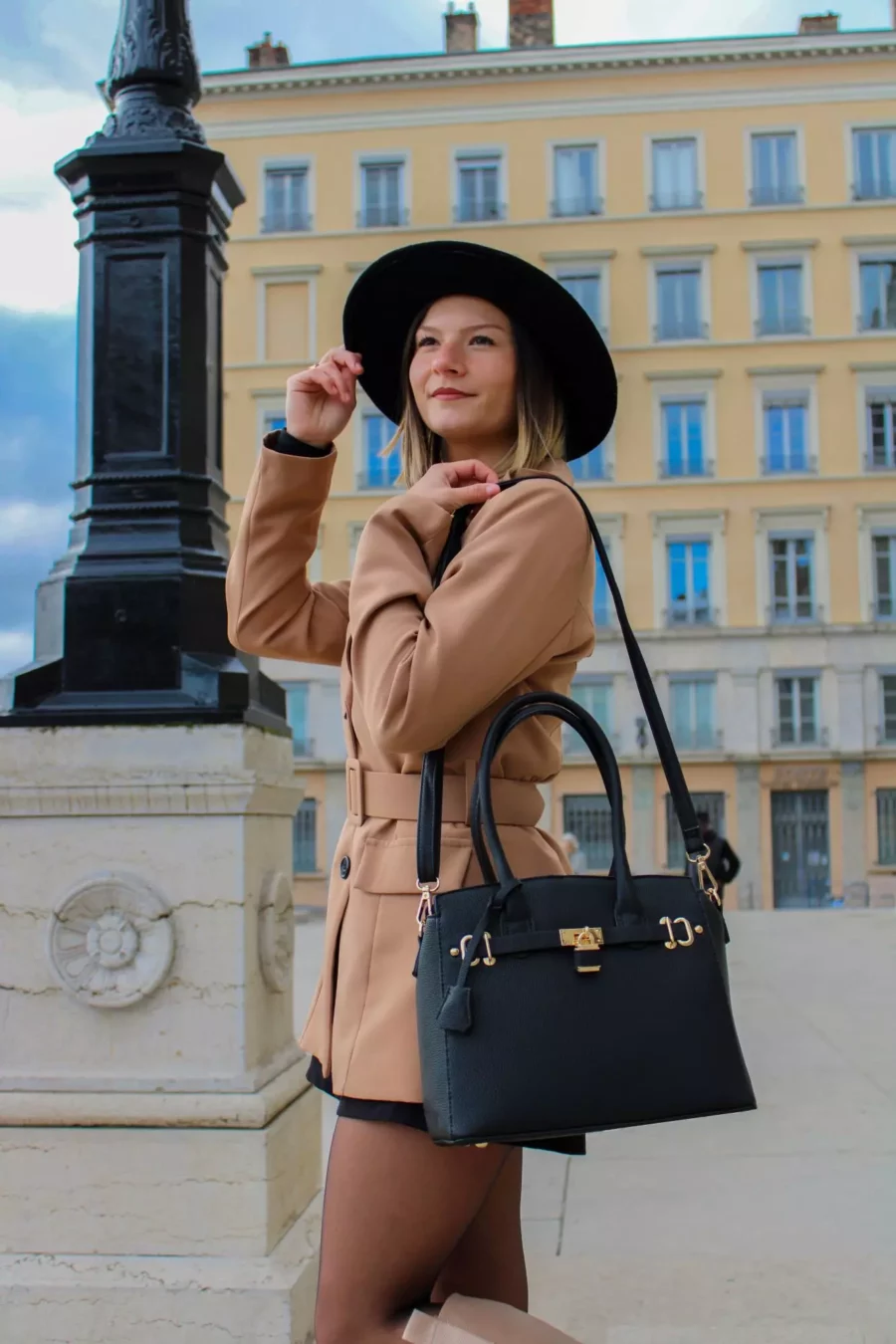 Le sac à main cadenas noir est en matière synthétique. C'est un accessoire tendance et pratique qui convient à toutes les occasions. Vous pouvez le porter à la main ou au coude grâce à ses solides double poignée. Vous pouvez également le porter à l'épaule ou en croisé grâce à sa bandoulière réglable et amovible. Il est équipé d'une fermeture à glissière, il dispose de deux compartiments séparés par une fermeture zippée, ainsi qu'une poche latérale zippée et deux poches ouvertes. Le petit cadenas doré situé au milieu du sac ajoute une touche de fantaisie à l'extérieur | Dovelya