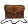 Le sac à main fer à cheval camel en cuir est en aspect croco. Avec des dimensions moyennes, ce sac est chic et élégant. Ce sac à main fer à cheval se ferme aisément grâce à un rabat et un fermoir aimanté aux finitions en métal pour plus de sécurité. L'intérieur possède deux compartiments avec une séparation zippée. Il est également muni d'une poche latérale zippée et d'une poche simple. Pour encore plus de praticité, il dispose d'une poche zippée à l'extérieur. Le modèle est équipé d'une bandoulière réglable en chaîne métallisée. Fabriqué en Italie | Dovelya