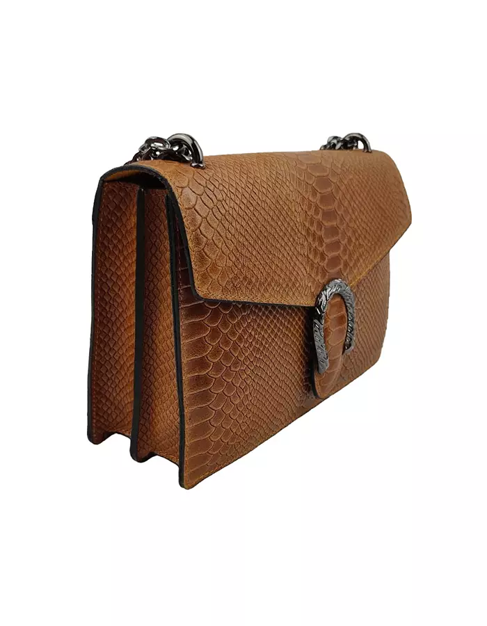 Le sac à main fer à cheval camel en cuir est en aspect croco. Avec des dimensions moyennes, ce sac est chic et élégant. Ce sac à main fer à cheval se ferme aisément grâce à un rabat et un fermoir aimanté aux finitions en métal pour plus de sécurité. L'intérieur possède deux compartiments avec une séparation zippée. Il est également muni d'une poche latérale zippée et d'une poche simple. Pour encore plus de praticité, il dispose d'une poche zippée à l'extérieur. Le modèle est équipé d'une bandoulière réglable en chaîne métallisée. Fabriqué en Italie | Dovelya
