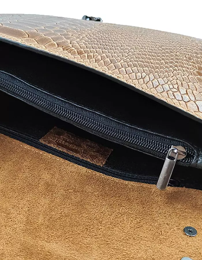 Le sac à main fer à cheval camel en cuir est en aspect croco. Avec des dimensions moyennes, ce sac est chic et élégant. Ce sac à main fer à cheval se ferme aisément grâce à un rabat et un fermoir aimanté aux finitions en métal pour plus de sécurité. L'intérieur possède deux compartiments avec une séparation zippée. Il est également muni d'une poche latérale zippée et d'une poche simple. Pour encore plus de praticité, il dispose d'une poche zippée à l'extérieur. Le modèle est équipé d'une bandoulière réglable en chaîne métallisée. Fabriqué en Italie | Dovelya