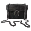 Le petit sac à main fer à cheval noir en cuir est en aspect croco. Avec des petites dimensions, ce sac est chic et élégant. Ce petit sac à main fer à cheval se ferme aisément grâce à un rabat et un fermoir aimanté aux finitions en métal pour plus de sécurité. L'intérieur possède un compartiment muni d'une poche latérale zippée et d'une poche simple. Pour encore plus de praticité, il dispose d'une poche zippée à l'extérieur. Le modèle est équipé d'une bandoulière réglable en chaîne métallisée. Fabriqué en Italie | Dovelya