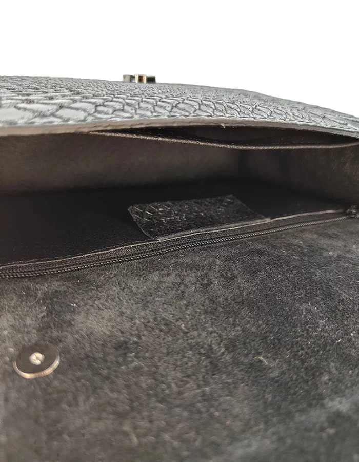 Le petit sac à main fer à cheval noir en cuir est en aspect croco. Avec des petites dimensions, ce sac est chic et élégant. Ce petit sac à main fer à cheval se ferme aisément grâce à un rabat et un fermoir aimanté aux finitions en métal pour plus de sécurité. L'intérieur possède un compartiment muni d'une poche latérale zippée et d'une poche simple. Pour encore plus de praticité, il dispose d'une poche zippée à l'extérieur. Le modèle est équipé d'une bandoulière réglable en chaîne métallisée. Fabriqué en Italie | Dovelya
